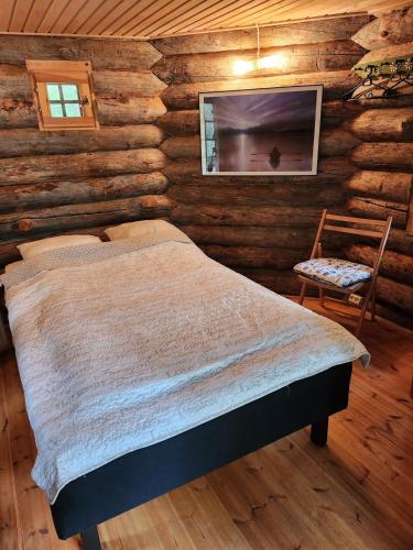 a bedroom with a bed in a log cabin at Villarkala in Heinola