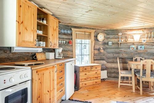 a kitchen with wooden walls and a stove top oven at Villarkala in Heinola