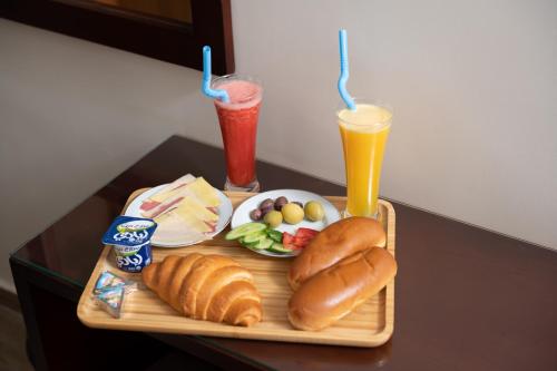 a tray of food with hot dogs and drinks on a table at Elyasmene in Qena