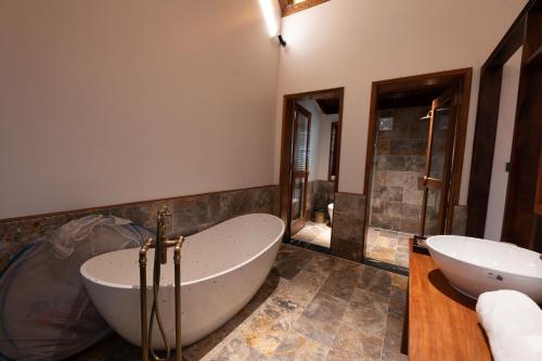 a large bathroom with a tub and a sink at Tam Coc Golden Fields Retreat in Vũ Lâm
