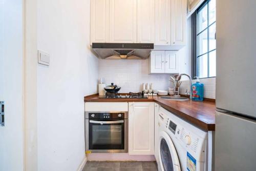 a kitchen with white cabinets and a dishwasher at 柃居 B&B - Jing'an Temple Branch in Shanghai