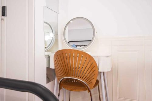 a chair sitting in front of a desk with two mirrors at 柃居 B&B - Jing'an Temple Branch in Shanghai