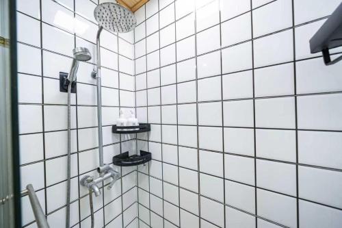 a bathroom with a shower with white tiled walls at 柃居 B&B - Jing'an Temple Branch in Shanghai