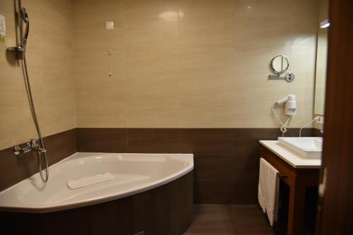 a bathroom with a bath tub and a sink at Aparthotel Vucko in Jahorina