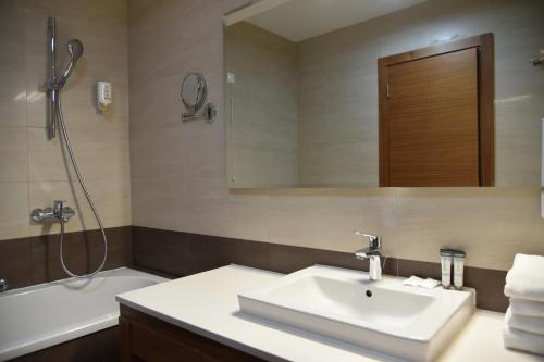 a bathroom with a sink and a shower and a tub at Aparthotel Vucko in Jahorina