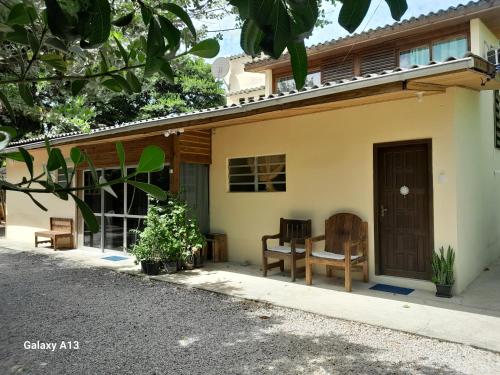 a house with a table and chairs in front of it at Residencial Álacre casa e cabana aluguel Ferrugem SC in Garopaba