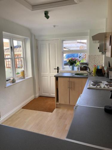 a kitchen with two windows and a counter top at Pelican House in Bridport