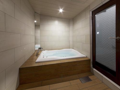 a large bath tub in a bathroom with a window at HOTEL BYAKKA 岐阜 -Gifu- in Gifu
