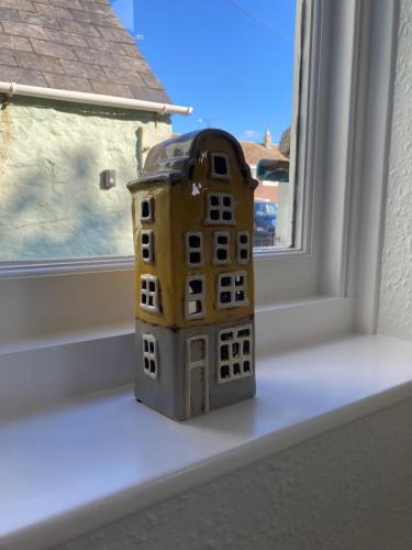 a toy building sitting on a window sill at Pelican House in Bridport