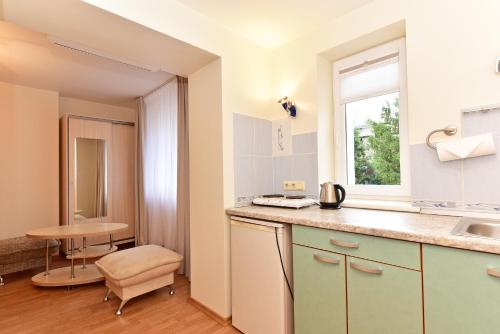 eine Küche mit Spüle, Tisch und Fenster in der Unterkunft Vilaverona in Palanga