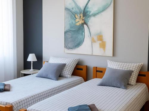 two beds in a room with a painting on the wall at Apartman 993 in Pale