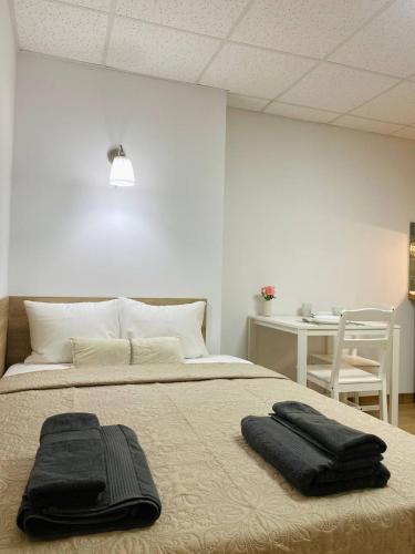 a bedroom with a bed with two black towels on it at BEACH Arguineguin FIRST LINE 8 studio CHG FAMILY HOTEL in Arguineguín