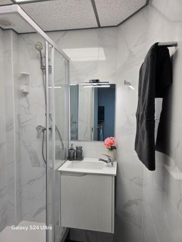 a bathroom with a sink and a shower with a mirror at BEACH Arguineguin FIRST LINE 8 studio CHG FAMILY HOTEL in Arguineguín