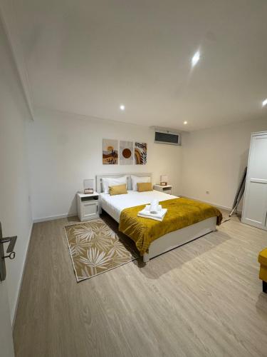a bedroom with a large bed and a rug at Cantinho do Avô Almeida in Nazaré