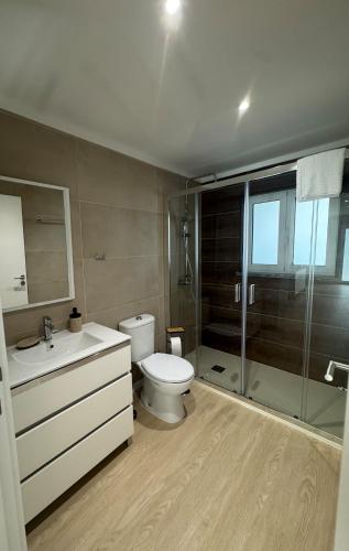 a bathroom with a toilet and a glass shower at Cantinho do Avô Almeida in Nazaré