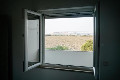 an open window with a view of a field at Casa Cleo al Mare con Free WiFi Netflix AC in Carrao