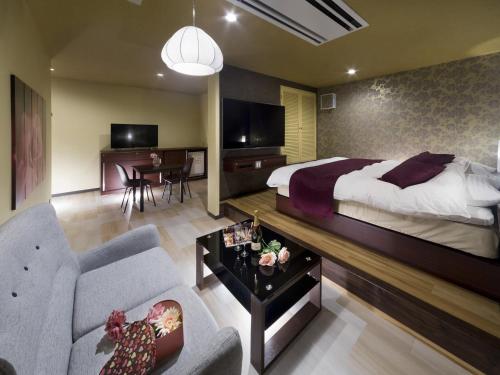 a hotel room with a bed and a living room at HOTEL BYAKKA 岐阜 -Gifu- in Gifu