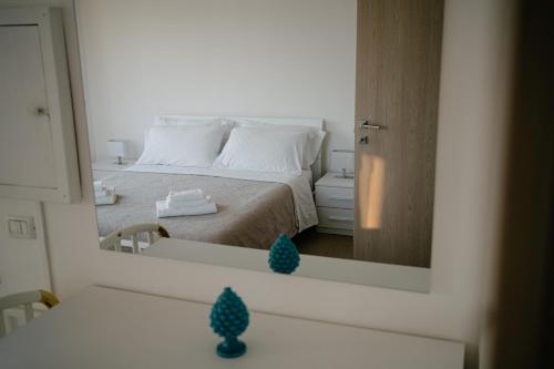 a reflection of a bedroom with a bed in a mirror at Casa Cleo al Mare con Free WiFi Netflix AC in Carrao