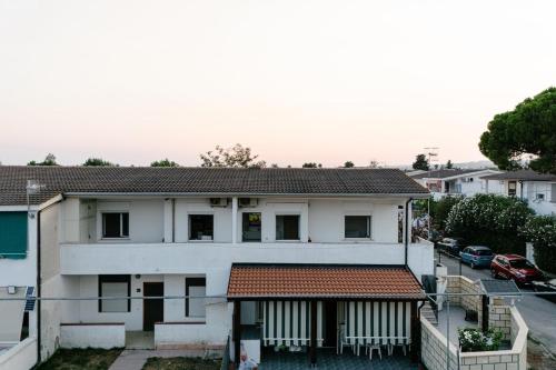 a white house with a red roof at Casa Cleo al Mare con Free WiFi Netflix AC in Carrao