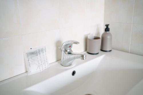 a sink with a faucet and two bottles on it at Casa Cleo al Mare con Free WiFi Netflix AC in Carrao