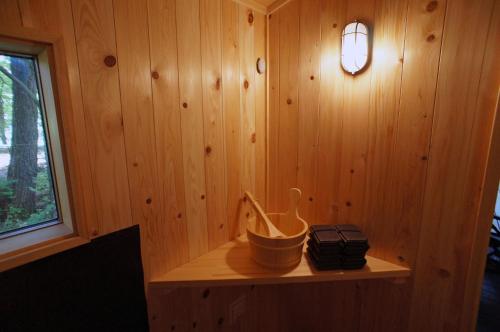 a room with a wooden wall with a light on it at HARUNA WING Private cottage in the forest overlooking the golf course in Tsumagoi