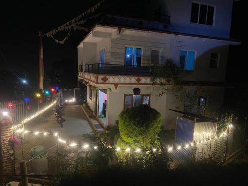 Un edificio con luces navideñas frente a él por la noche. en Aanshi Homestay, en Nagarkot