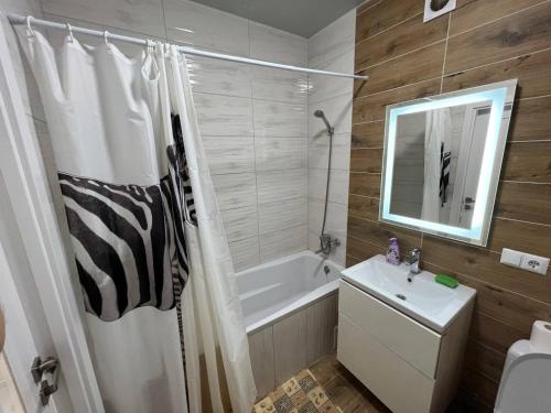 ein Badezimmer mit Badewanne, Waschbecken und Dusche in der Unterkunft Затишна квартира в Центрі! Новий двір - Galka Apartment in Iwano-Frankiwsk