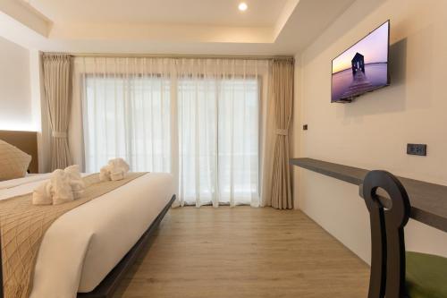 a hotel room with a bed and a flat screen tv at XL PATONG Hotel in Patong Beach