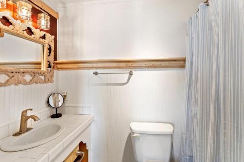 a bathroom with a sink and a toilet and a mirror at SWC13 - Sea oar Sound in Hatteras