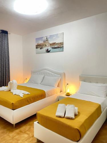 two beds in a room with yellow and white at St Suite Venice in Venice