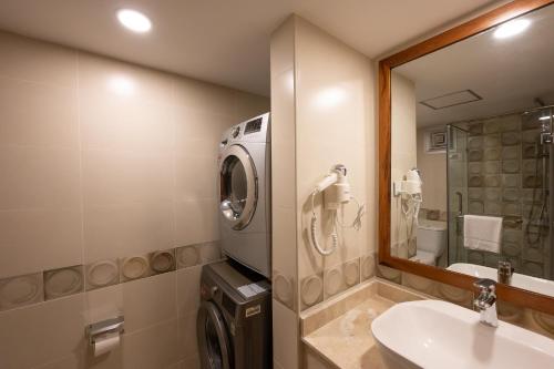 a bathroom with a washing machine and a sink at Sea Cliff Court Hotel & Luxury Apartments in Dar es Salaam
