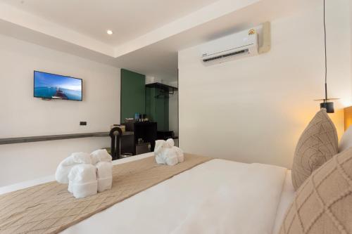 a bedroom with a white bed with two towels at XL PATONG Hotel in Patong Beach