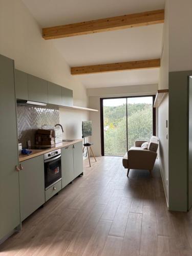 a kitchen with a living room with a couch at Casa da Miquinhas in Murça