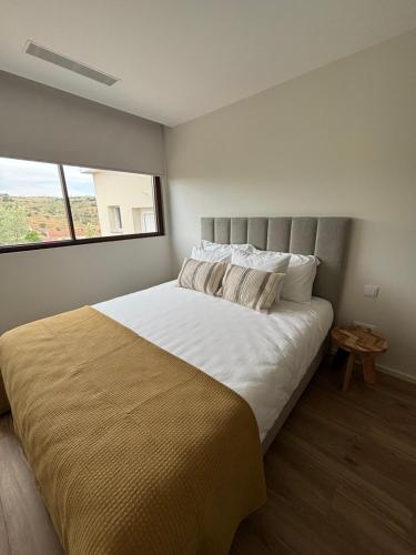 a bedroom with a large bed with a large window at Casa da Miquinhas in Murça