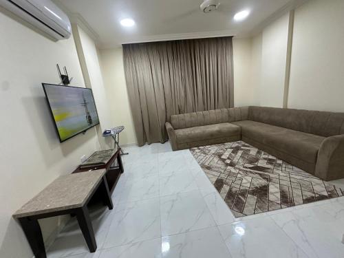 a living room with a couch and a tv at Valley Flower in Salalah