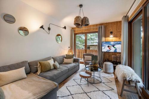 a living room with a couch and a tv at Appartement 4 à la Ferme des Lanches au Praz in Courchevel