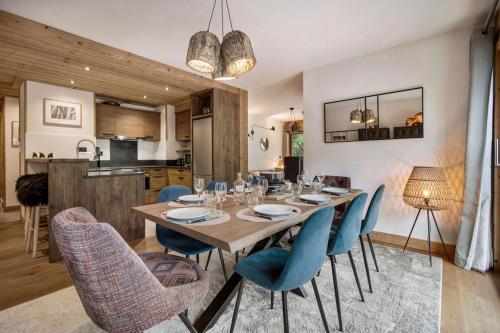 a dining room with a table and blue chairs at Appartement 4 à la Ferme des Lanches au Praz in Courchevel