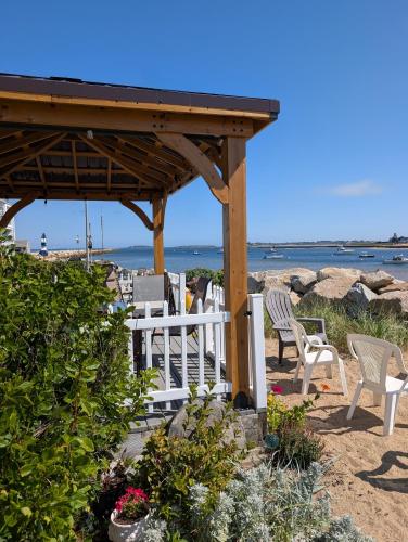 a gazebo on the beach with chairs and flowers at Beach Cottage in Saco