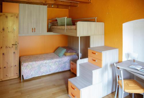 a bedroom with two bunk beds and a desk at 123 la casa nel bosco in Curino