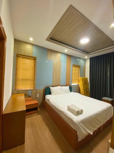 a bedroom with a bed with two towels on it at Hoàng Gia villa Novaworld in Bình Sum