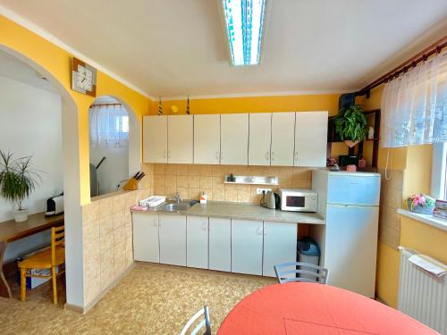 a kitchen with white cabinets and a white refrigerator at One Floor under High Tatras in Malý Slavkov