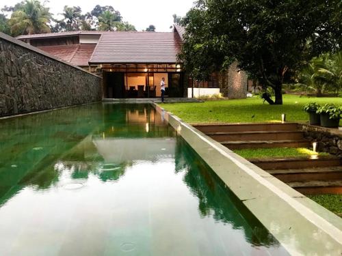 a pool of water in front of a building at Sweet Hive Villa in Kuttāttukulam