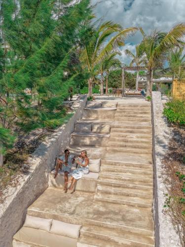 two people sitting on the stairs at the beach at Kaskazi Hotel Zanzibar in Jambiani