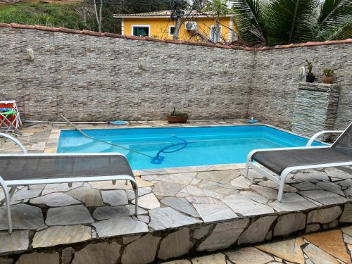 una piscina con due sedie a sdraio di Casa vacacional con piscina a Búzios