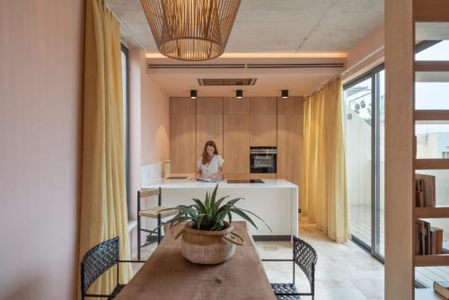 a woman is sitting at a counter in a kitchen at Medieval Knights house GF with Seaview at the Three Cities Marina in Senglea