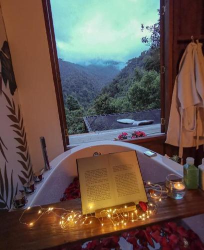 a book sitting in a bath tub with a window at El Color de Mis Rêves in Villamaría