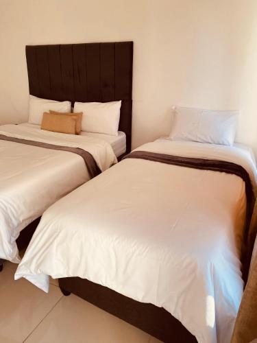 two beds sitting next to each other in a room at Khayelihle Guest house in Benoni