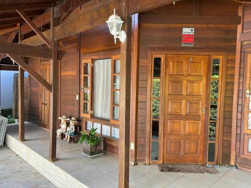 una veranda di una casa con porta in legno di Aconchegante Casa - Morada da Praia a Bertioga