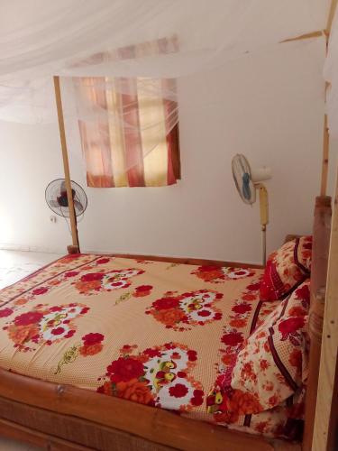 Bett mit Daunendecke in einem Schlafzimmer in der Unterkunft Chez Mado in Ndangane