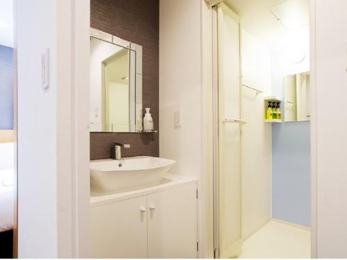 un baño con lavabo y espejo en レンブラントイン青森, en Aomori